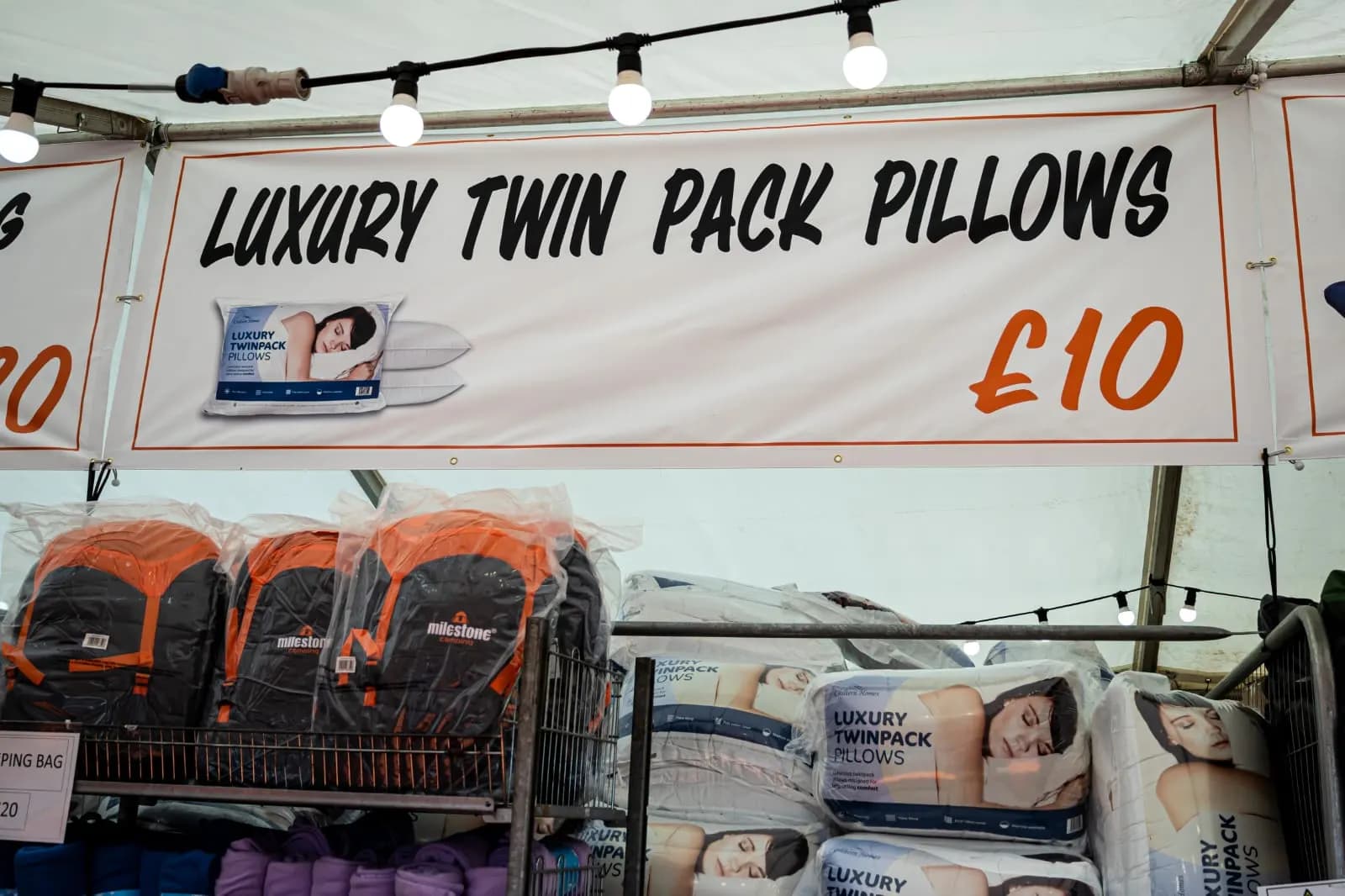 A Luxury Twin Pack Pillows banner above shelves of sleeping bags and packs of pillows.